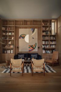 Stylish modern living room with warm wooden tones and vibrant geometric wall art.