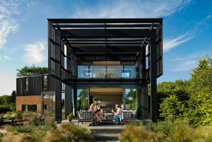 Contemporary home harmonising with nature, featuring expansive glass windows and inviting outdoor spaces.