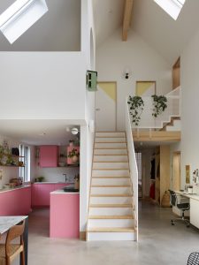 Stylish contemporary home interior featuring open spaces, pink kitchen cabinetry, and natural light.