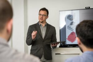 Professional man presenting on product design in a modern, minimalistic corporate setting.