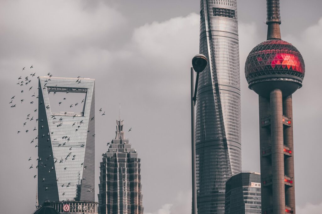 Shanghai cityscape with iconic skyscrapers and partly cloudy sky.