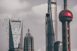 Shanghai cityscape with iconic skyscrapers and partly cloudy sky.