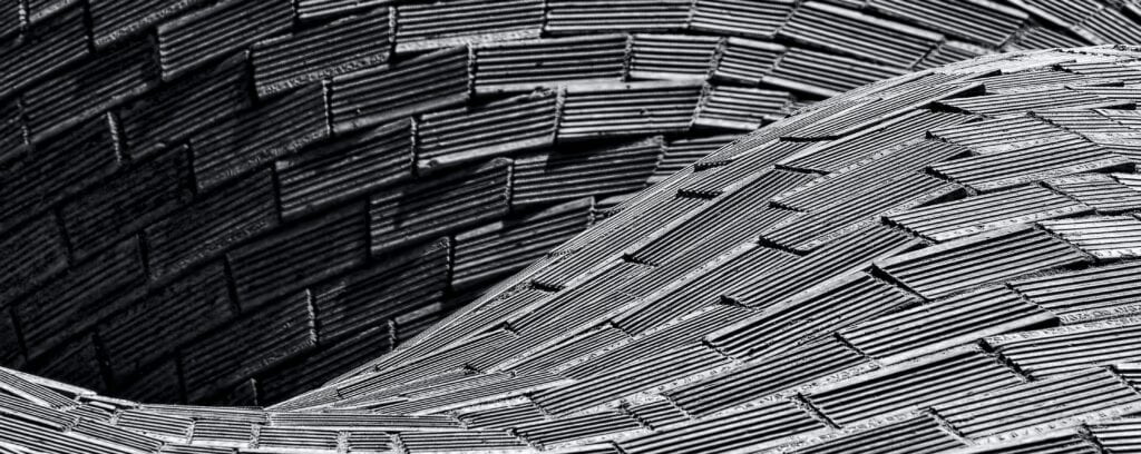 Intricate spiraling pattern of woven tiles creating depth and motion.