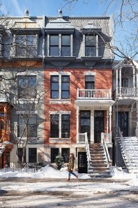 Picturesque winter townhouses adorned with snow, showcasing vibrant architecture and peaceful urban streets.